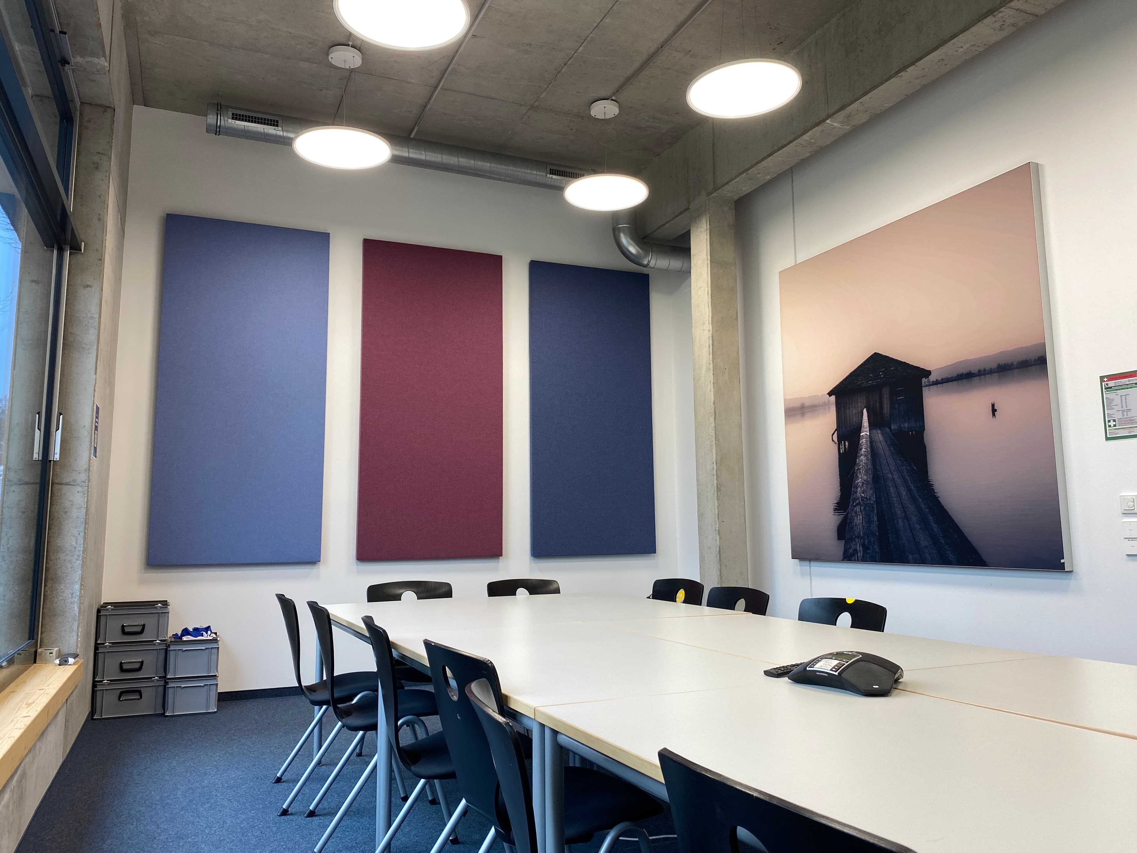 Besprechungsraum mit drei großen, farbigen Wand-Schallschutzelementen aus Merino-Stoff neben einem Bild.